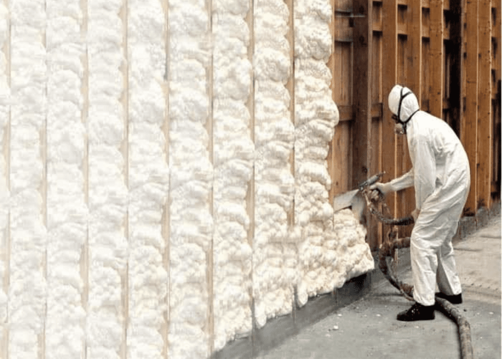 Man spraying spray foam using a spray gun